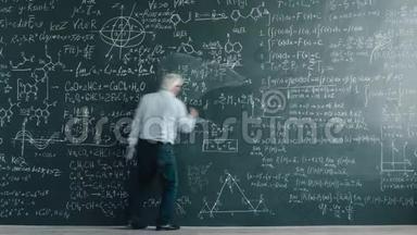 聪明的成熟男人教授在黑板上书写<strong>方程式</strong>